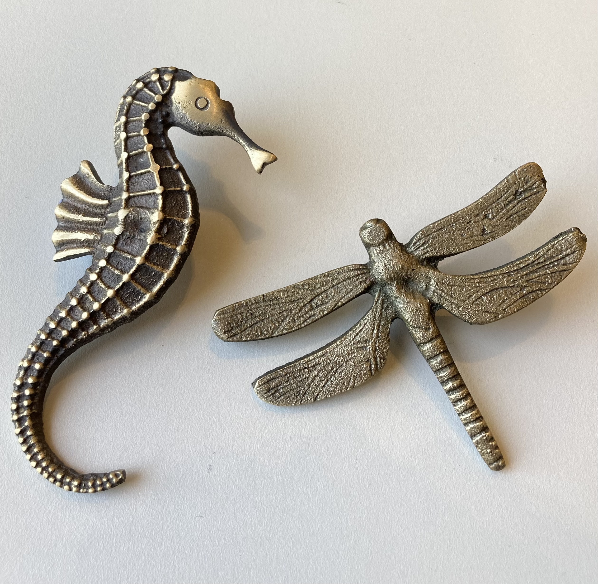 Bespoke solid brass decorative hardware including detailed seahorse handle and dragonfly drawer pull by Stillium.